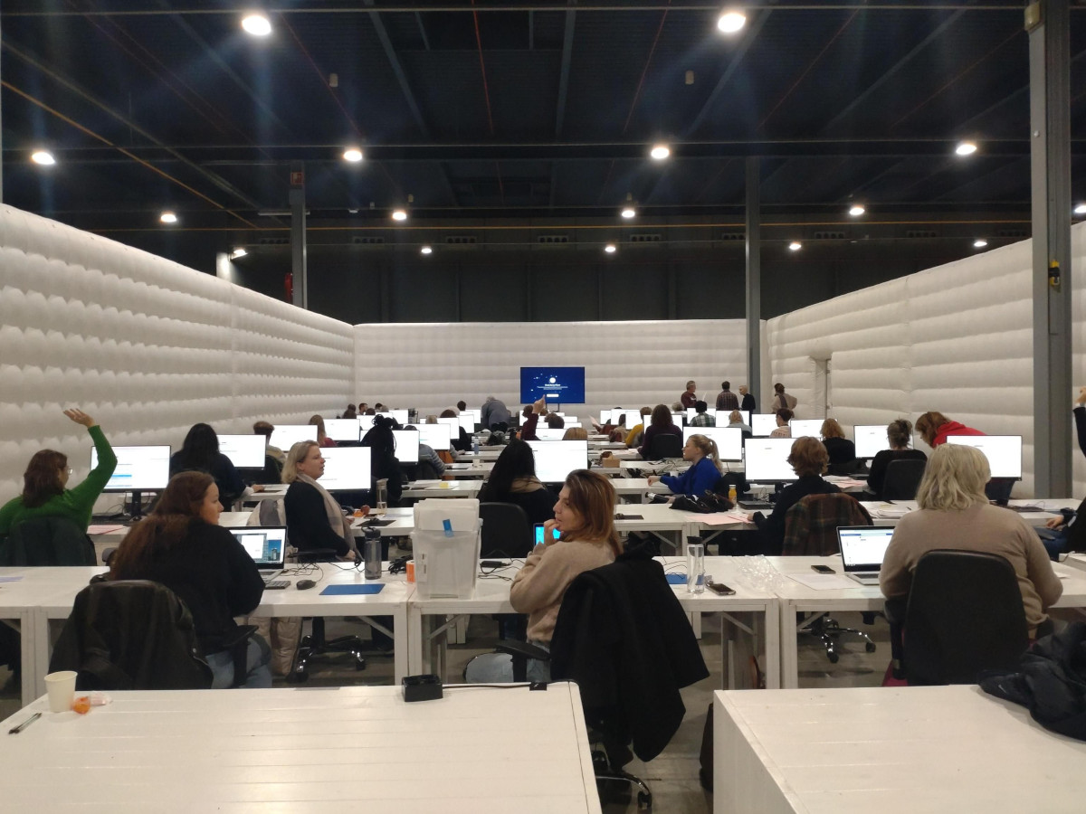 a room with people sitting behind computers